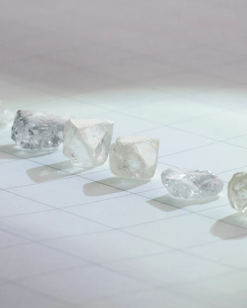 six natural diamonds lined up on a quadricular paper sheet