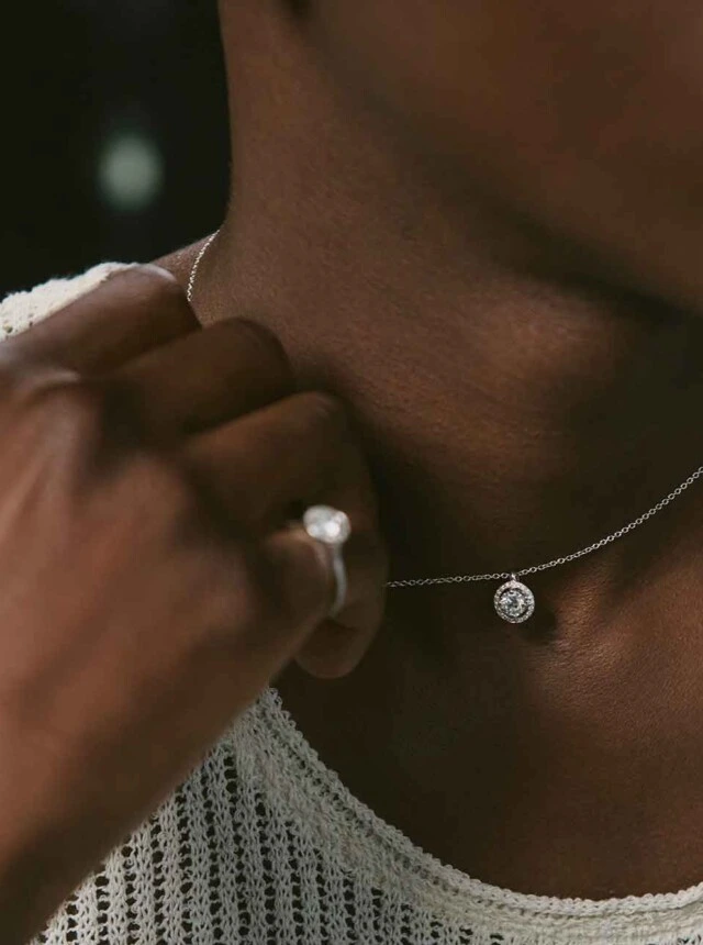 person wearing a diamond necklace and ring