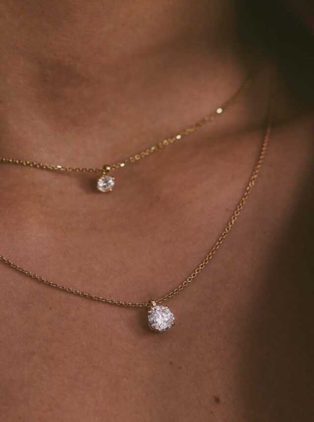 Woman wearing two diamond necklaces around her neck