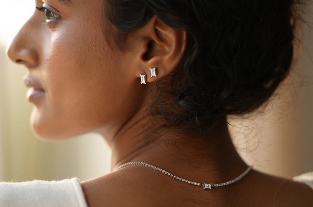 A woman wearing natural diamond studs and a diamond necklace