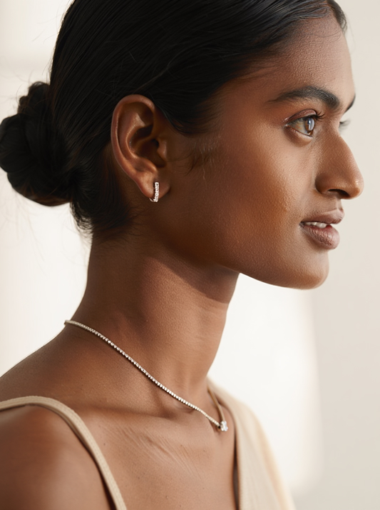 Side profile of a model wearing natural diamond earrings and a delicate diamond necklace