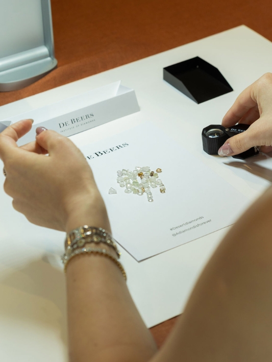 Rough diamonds in various colours placed on a white surface
