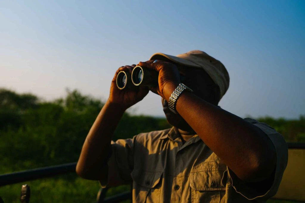 Man looking through binoculars outdoors