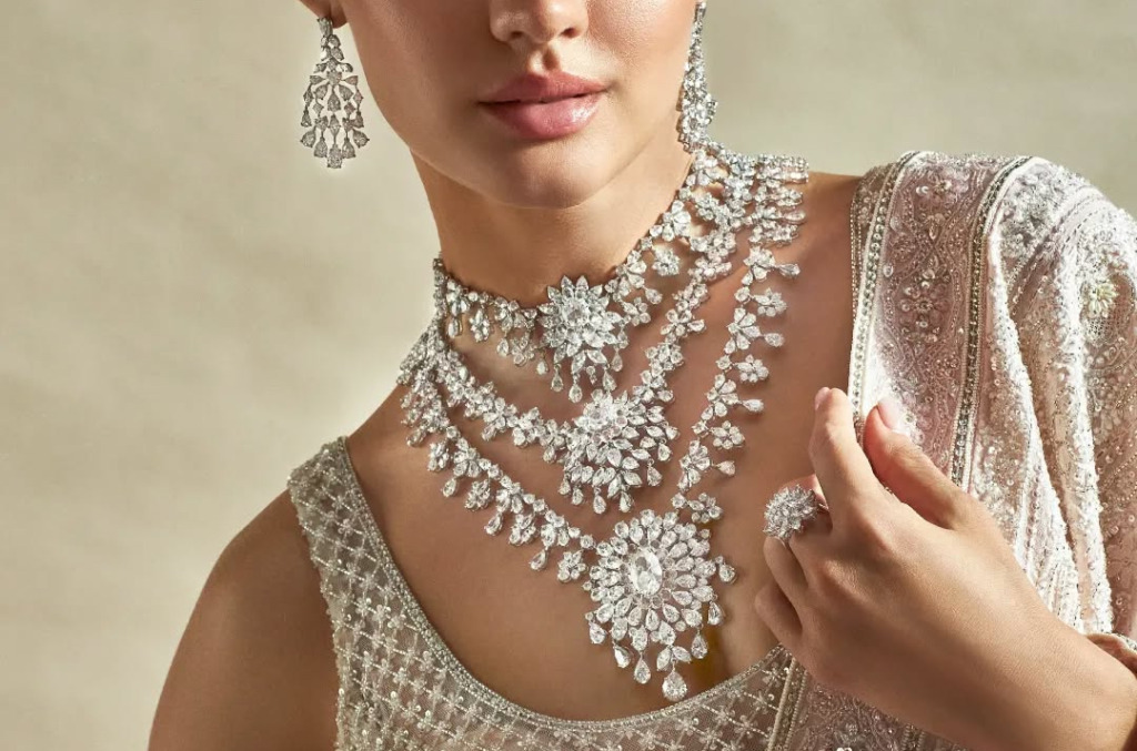 Close up of a woman wearing a layered diamond necklace and matching earrings