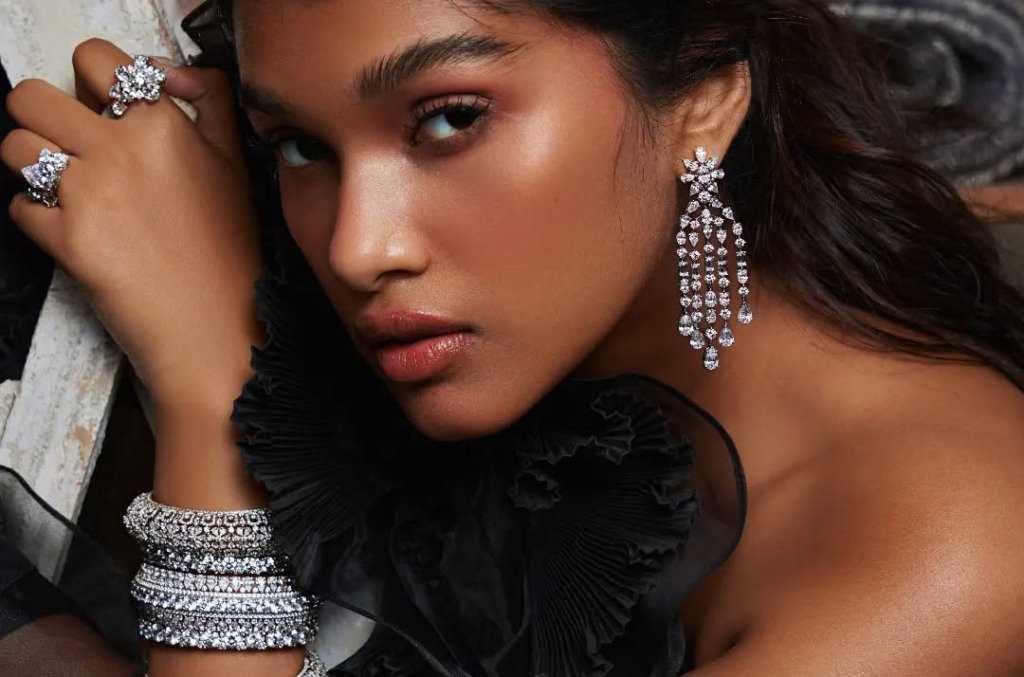 Model wearing a stack of diamond bangles, rings and earrings
