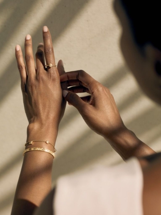 Woman wearing gold and natural diamond jewellery on her wrist and finger