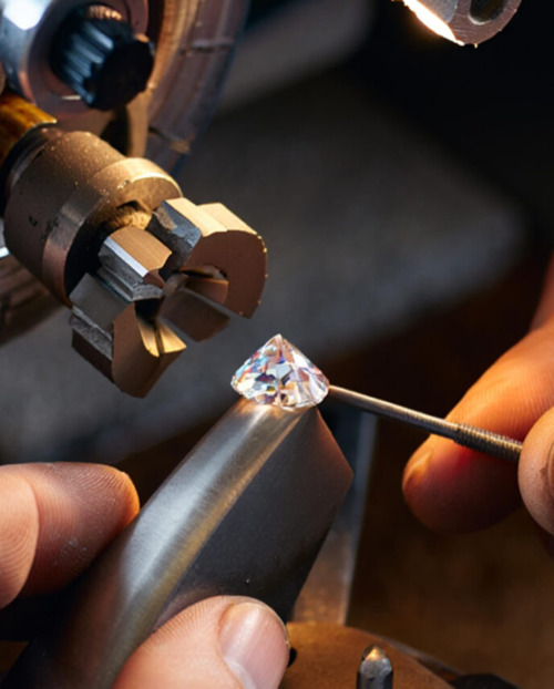 A polished natural diamond being handled