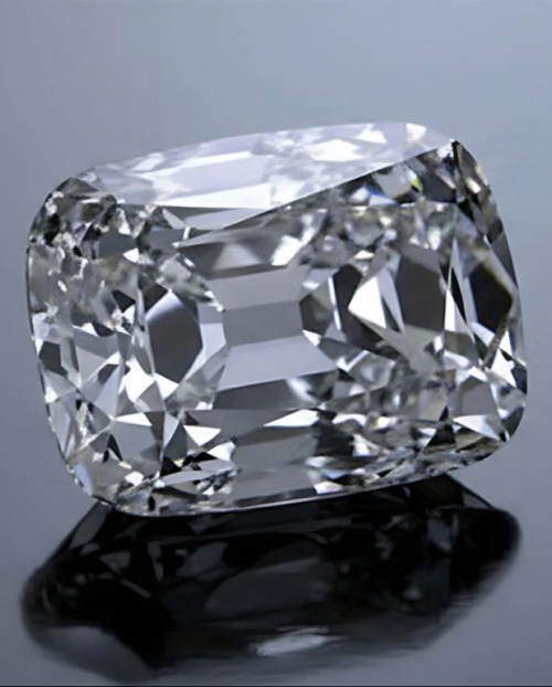 A well cut natural diamond against a grey background