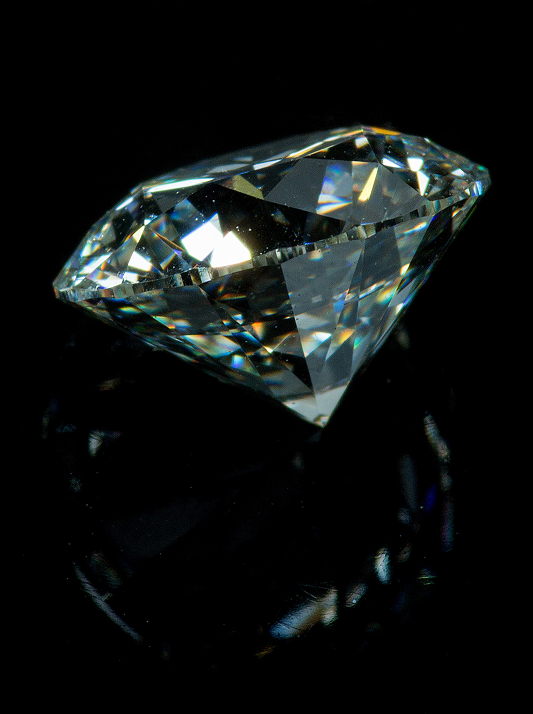 A cut natural diamond against a black background