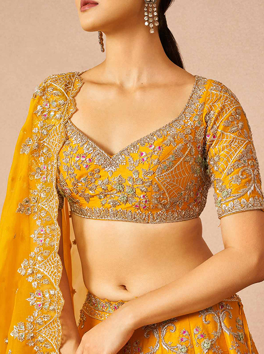 Close up of a model wearing a honey coloured lehenga