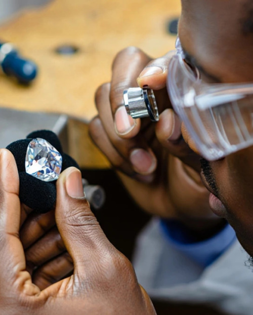 Man looking at a diamond during the process of diamond cutting