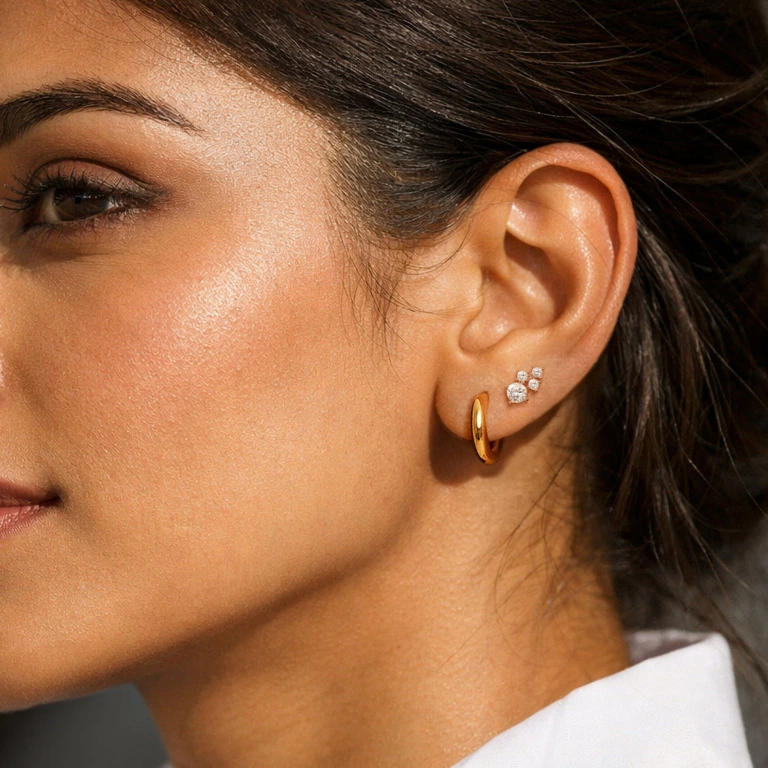 Model wearing a hoop and a cluster diamond earring on her second piercing