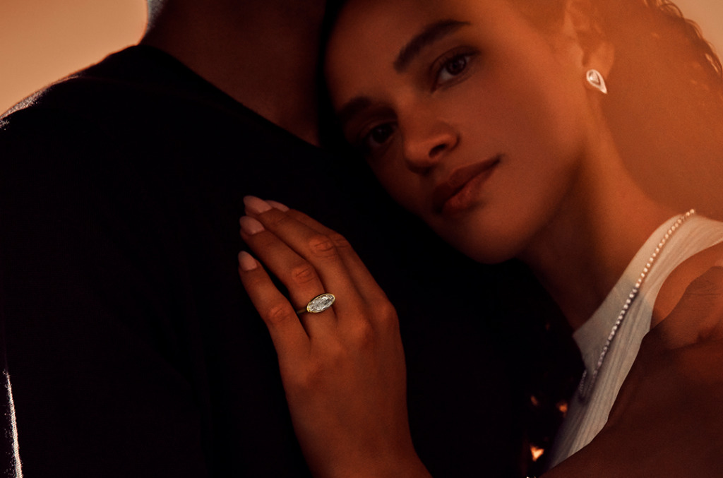 A woman wearing natural diamond jewellery in Desert shades leaning against her partner