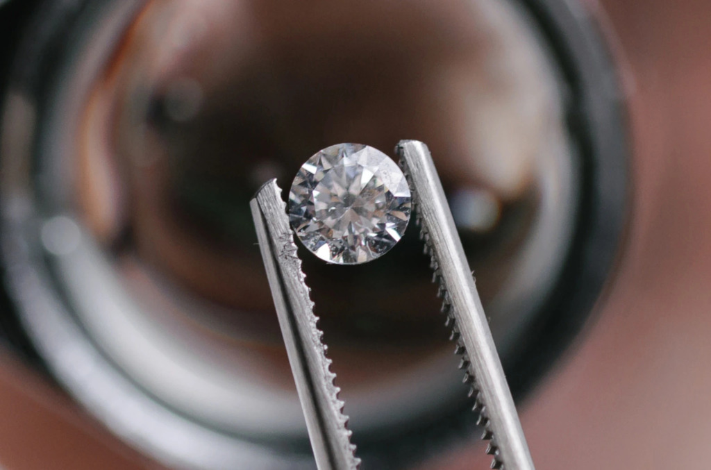 Close up of a round brilliant diamond being held up
