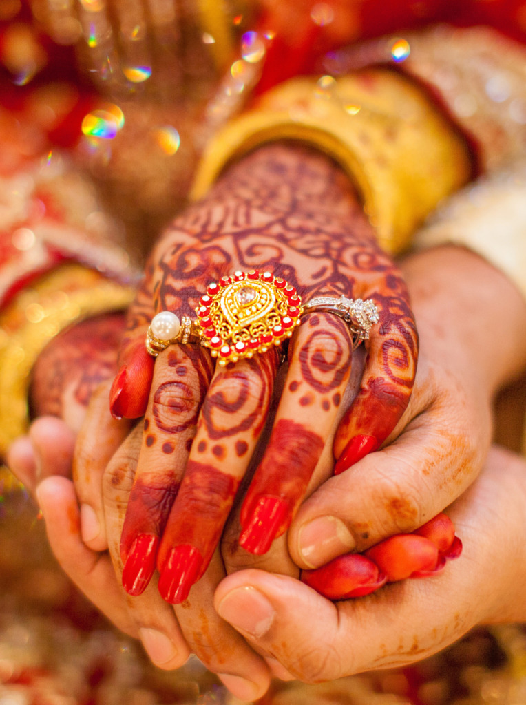 An Indian woman's hand on her wedding day wearing a diamond ring