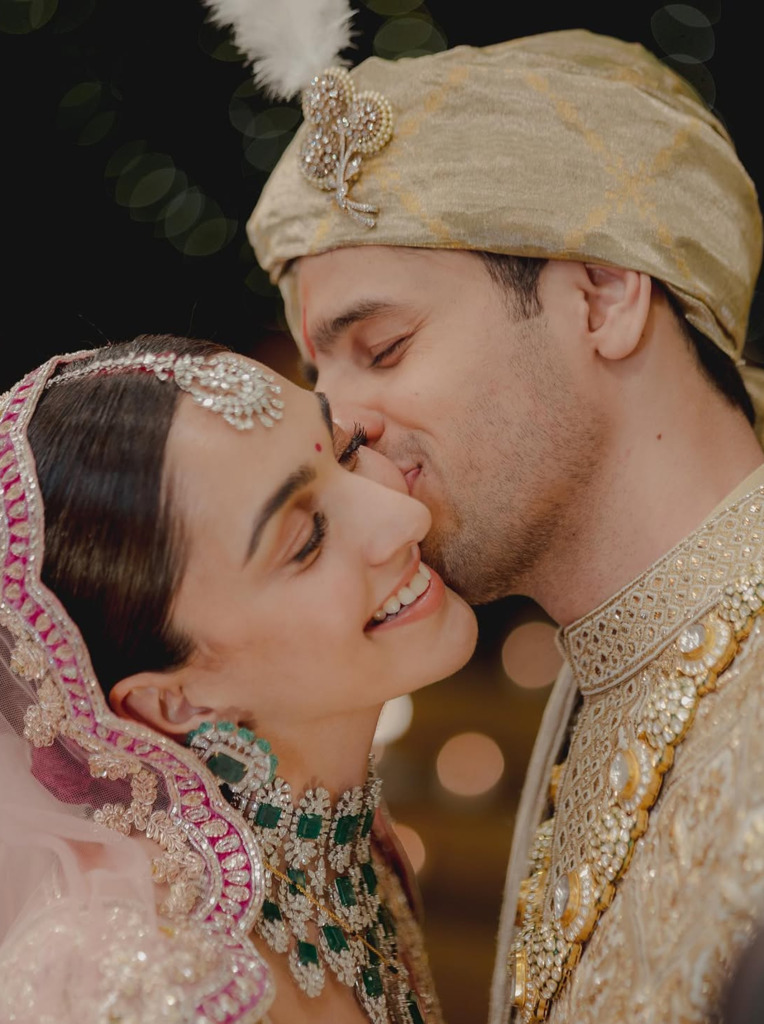 Kiara Advani wearing a diamond maang tikka on her wedding day, photographed with her husband