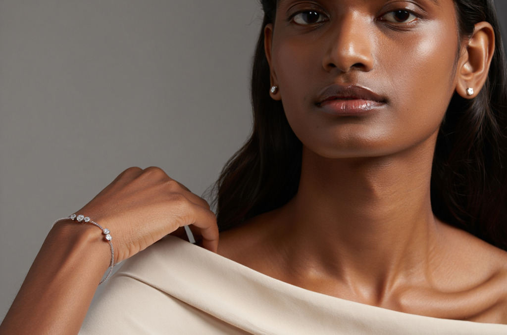 A young woman wearing diamond stud earrings and a minimalist diamond bracelet