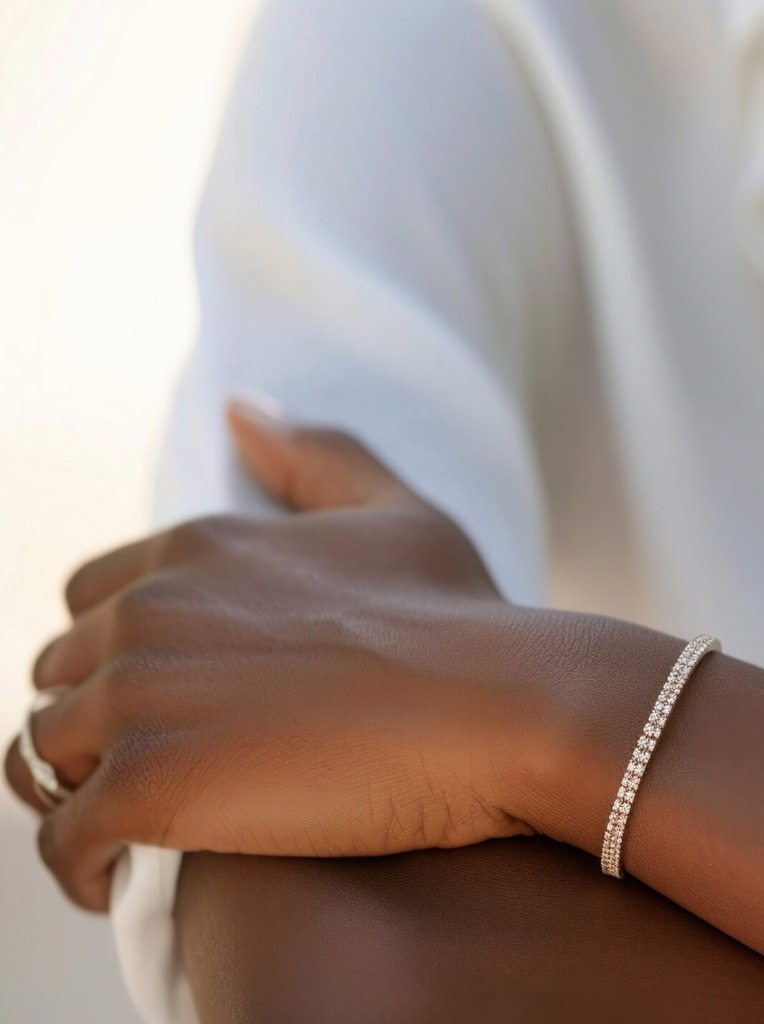 Person wearing diamond tennis bracelet and ring