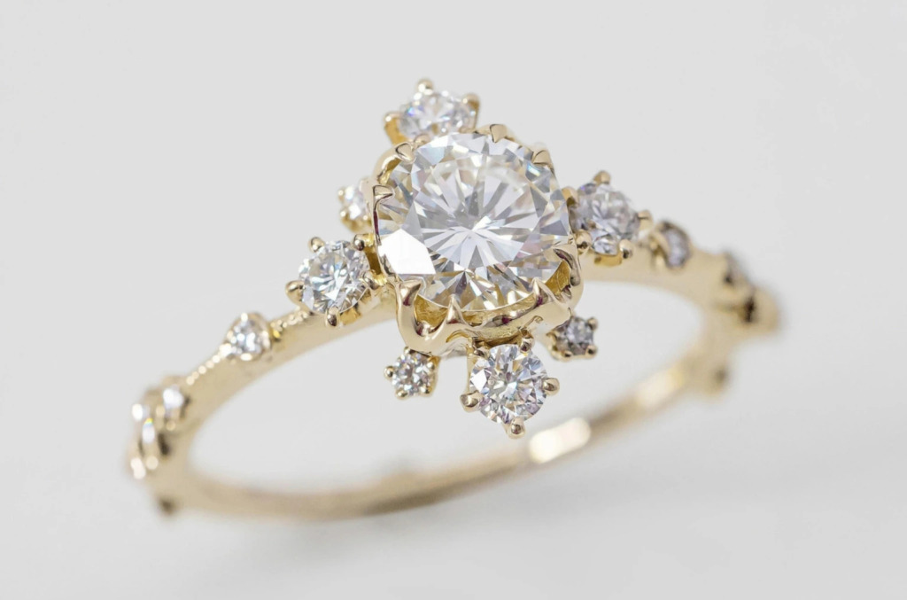 Close up of a classic round diamond ring framed with many smaller diamonds