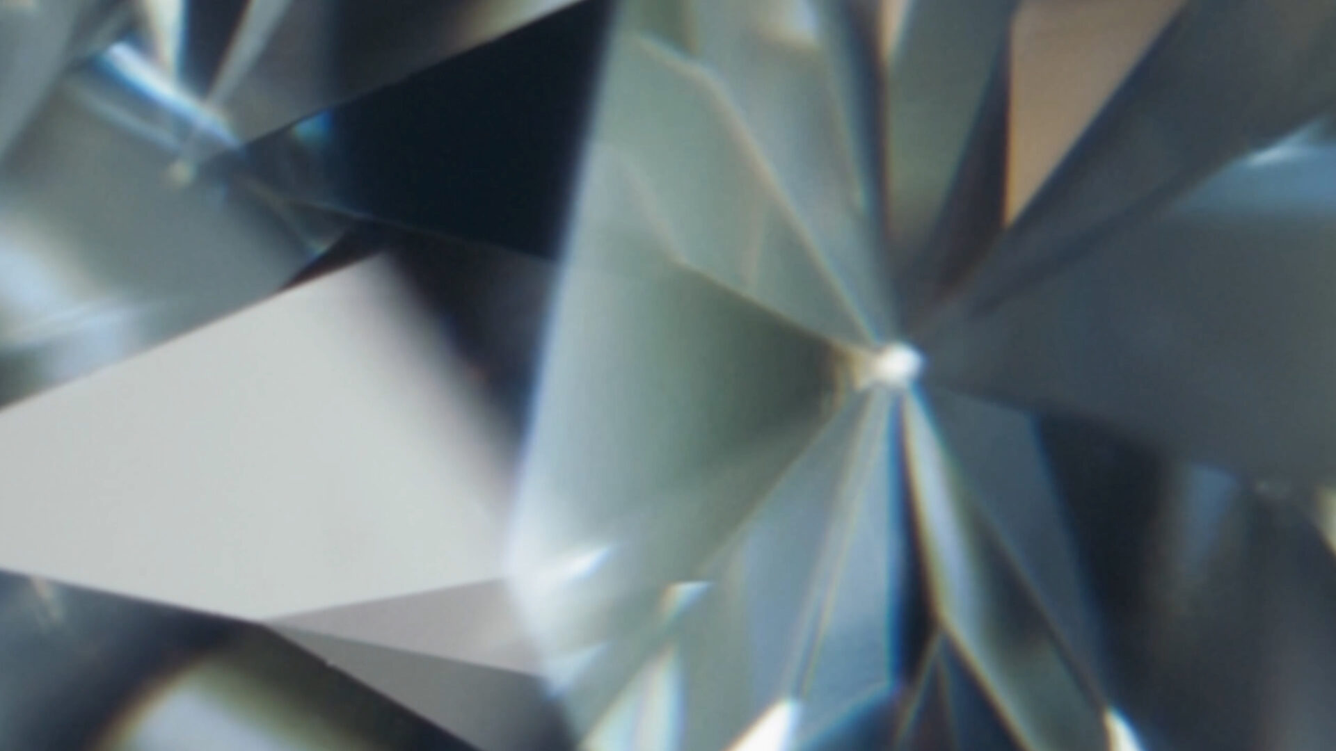 Extreme macro shot of a natural diamond’s facets, capturing the detail of its cut and light reflection.