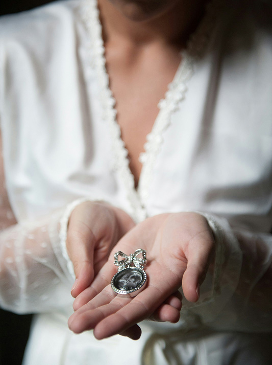 Female hand holding silver and diamond brooch