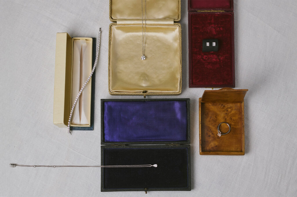 A selection of natural diamond jewelry in different colored jewelry boxes