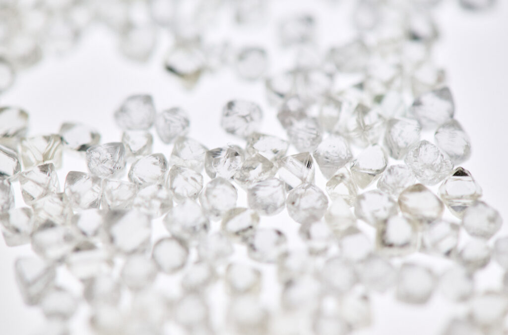 Rough clear natural diamonds on white lightbox background