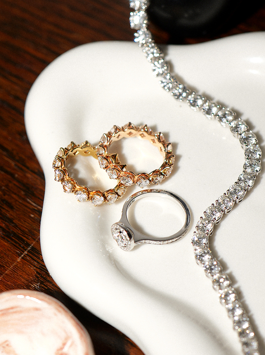 A selection of diamond jewelry on a white plate