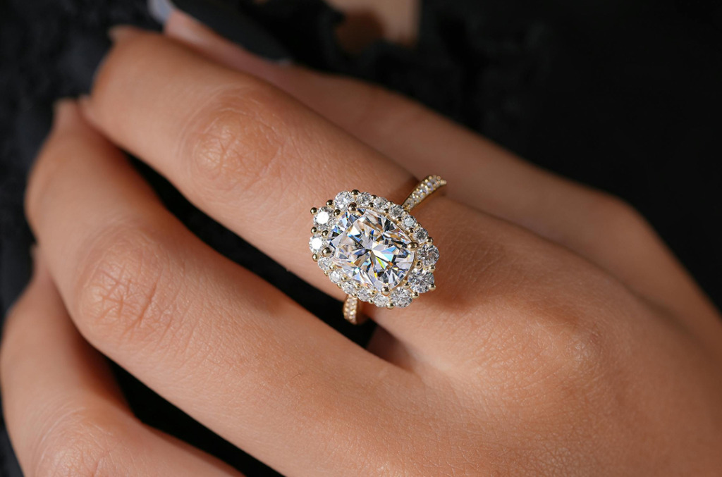 White oval-cut diamond ring on white woman's finger