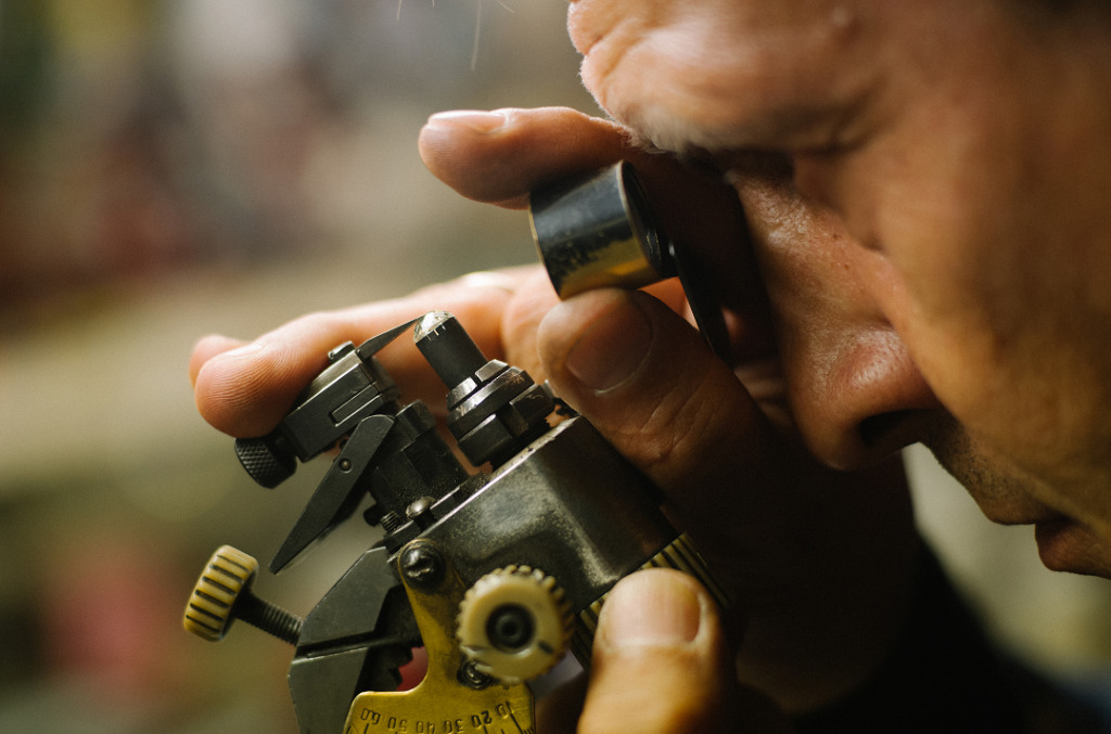 Man looking at diamond through microscope
