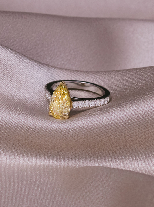 Fancy yellow diamond ring on grey silk background