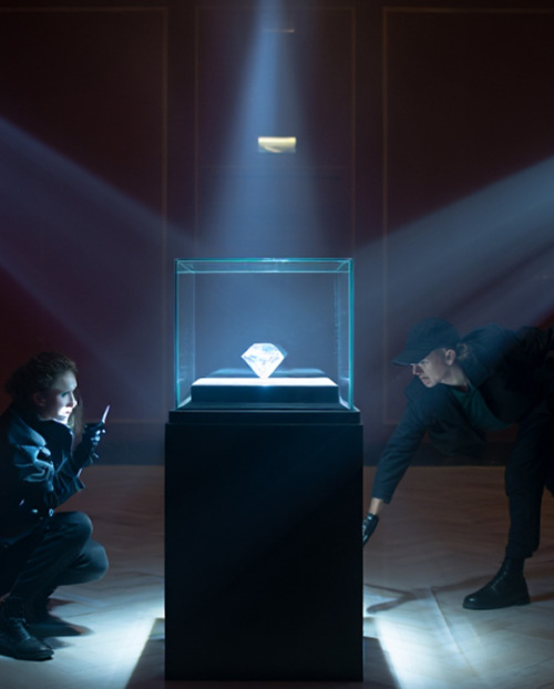 Two robbers trying to steal a diamond from a glass security box