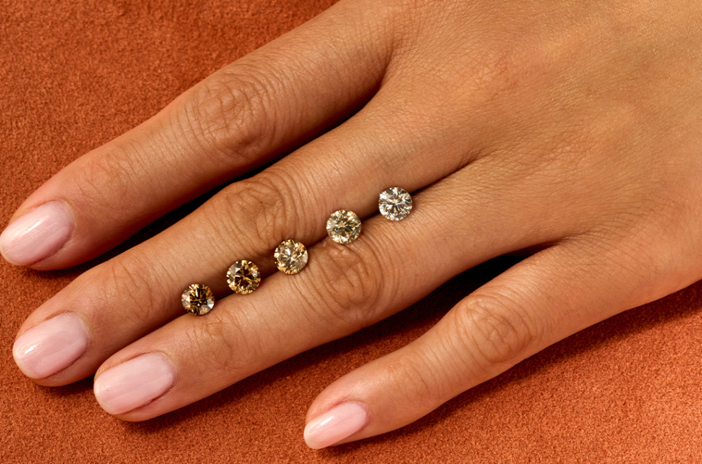 Olive hand on orange background with ombre of cut desert diamonds