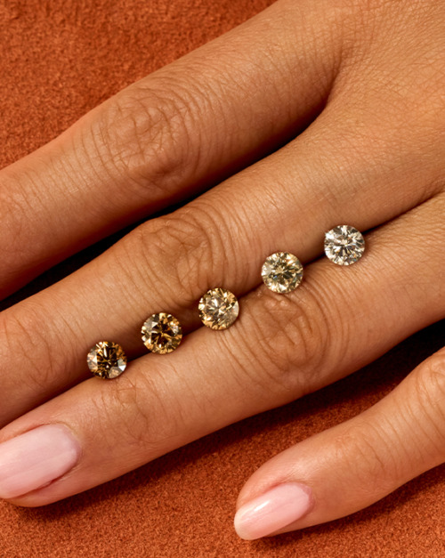 Olive hand on orange background with ombre of cut desert diamonds