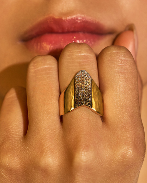 Female olive-skinned hand with desert diamond ring on middle finger