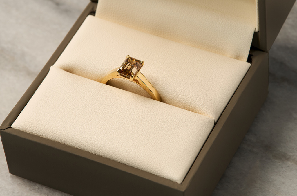 Brown diamond solitaire engagement ring in leather box