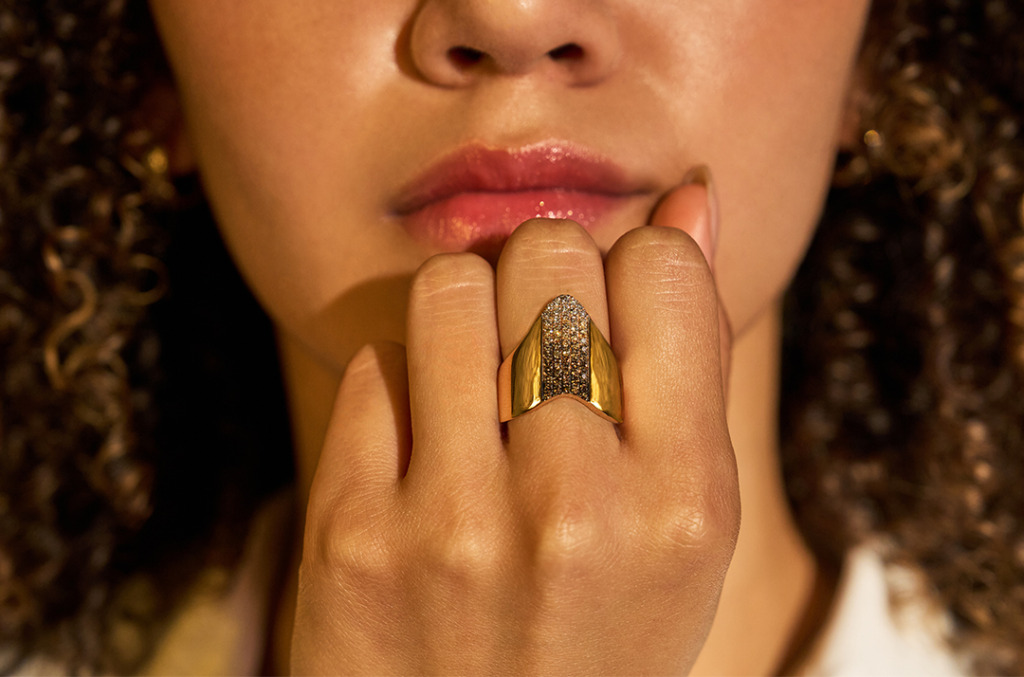 Female olive-skinned hand with desert diamond ring on middle finger