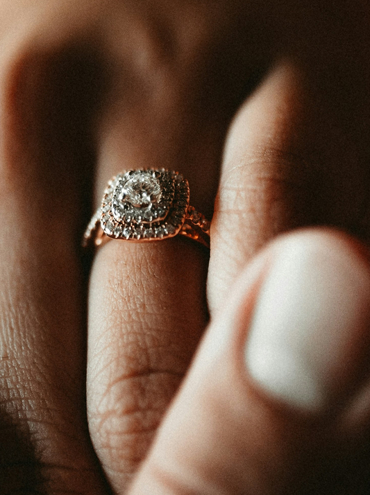A halo-style engagement ring design in rose gold
