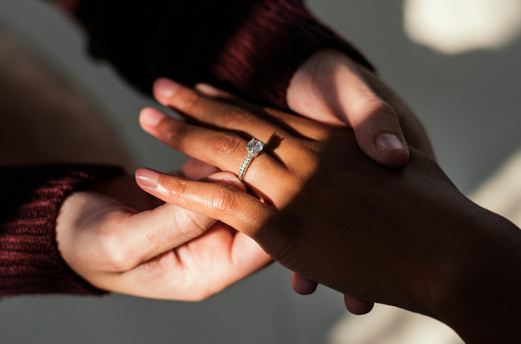 A proposal scene featuring a solitaire engagement ring with natural diamonds