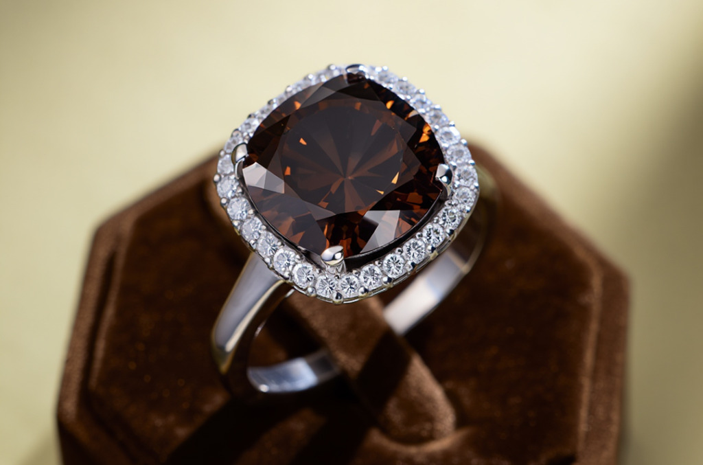 A cushion-cut Sunset Brown Desert diamond ring set in white gold with a halo of smaller white diamonds, glowing with deep espresso and bronze tones.