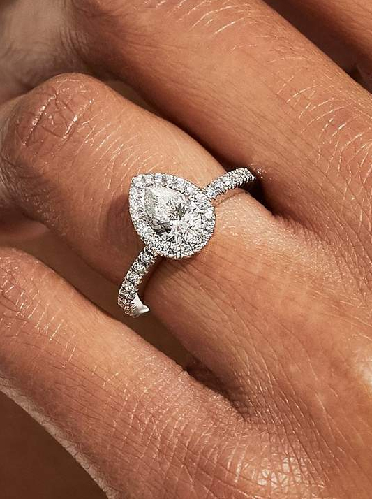 A halo-style engagement ring featuring a pear-shaped diamond