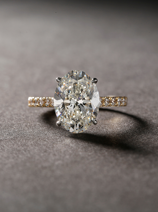 Oval-cut natural diamond engagement ring on a pavé diamond band, shown in soft studio lighting against a smooth grey background.