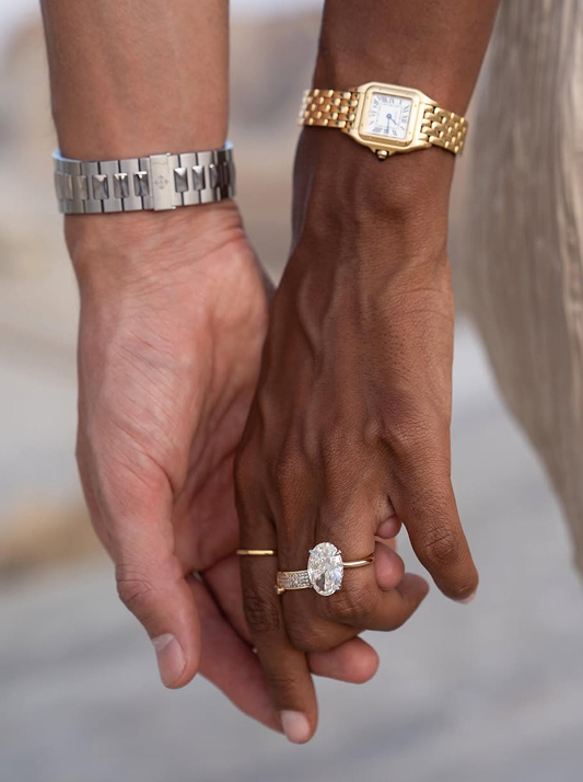 Close-up of Jasmine Tookes and her fiancé holding hands, highlighting her oval natural diamond engagement ring.
