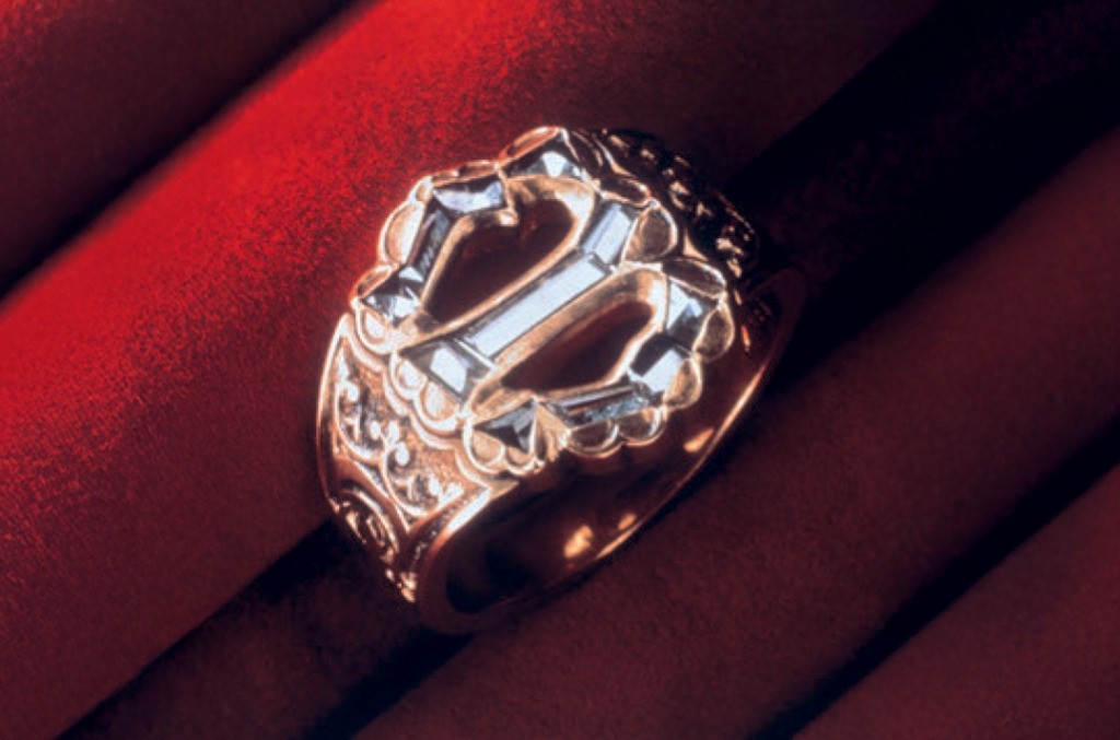 Close-up of a historic-style gold ring set with thin diamond shards arranged in the shape of the letter “M,” inspired by the 1477 engagement of Archduke Maximilian and Mary of Burgundy.