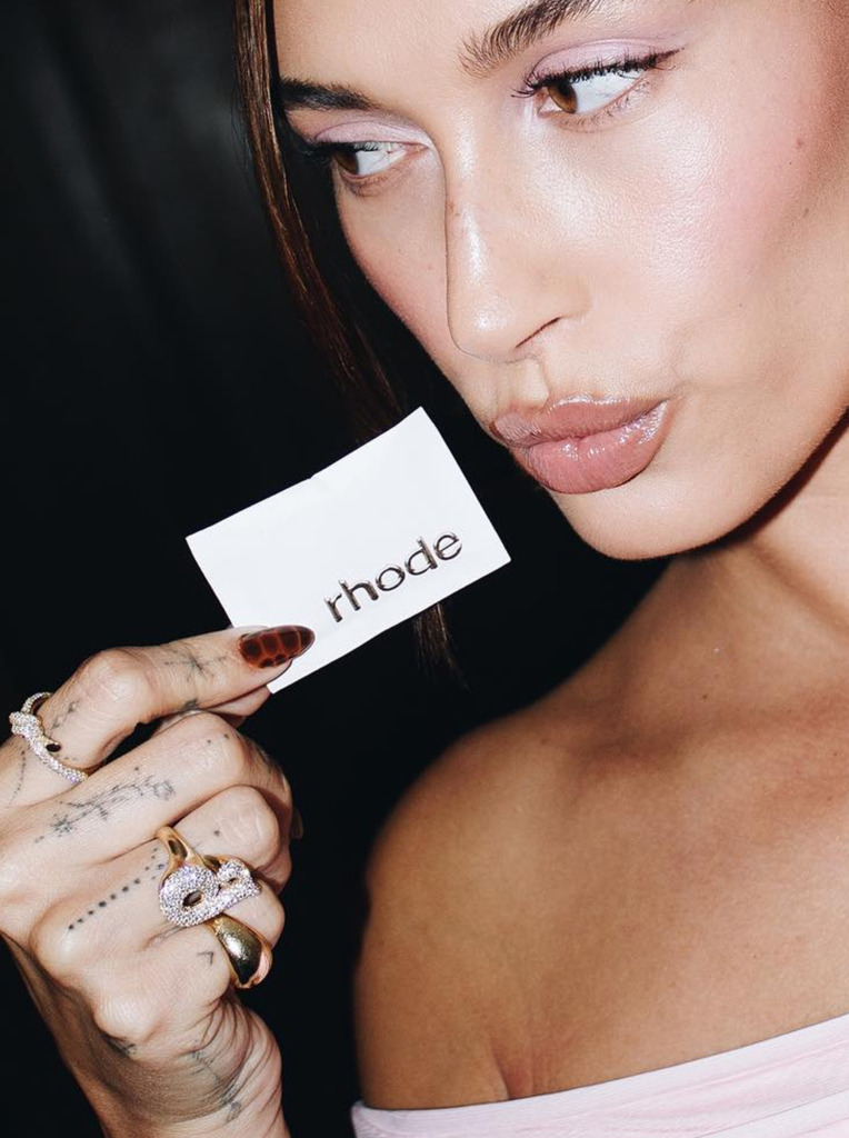 Hailey Bieber wearing diamond initial ring, styled as part of her everyday look.