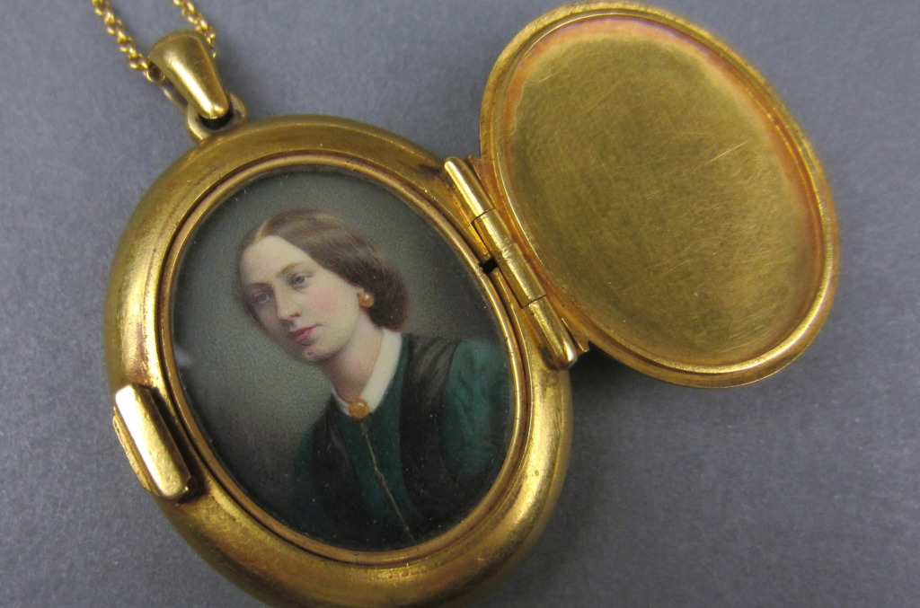 Victorian-inspired gold locket opened to reveal a miniature portrait, echoing the personalized diamond pendants popular in the 19th century.