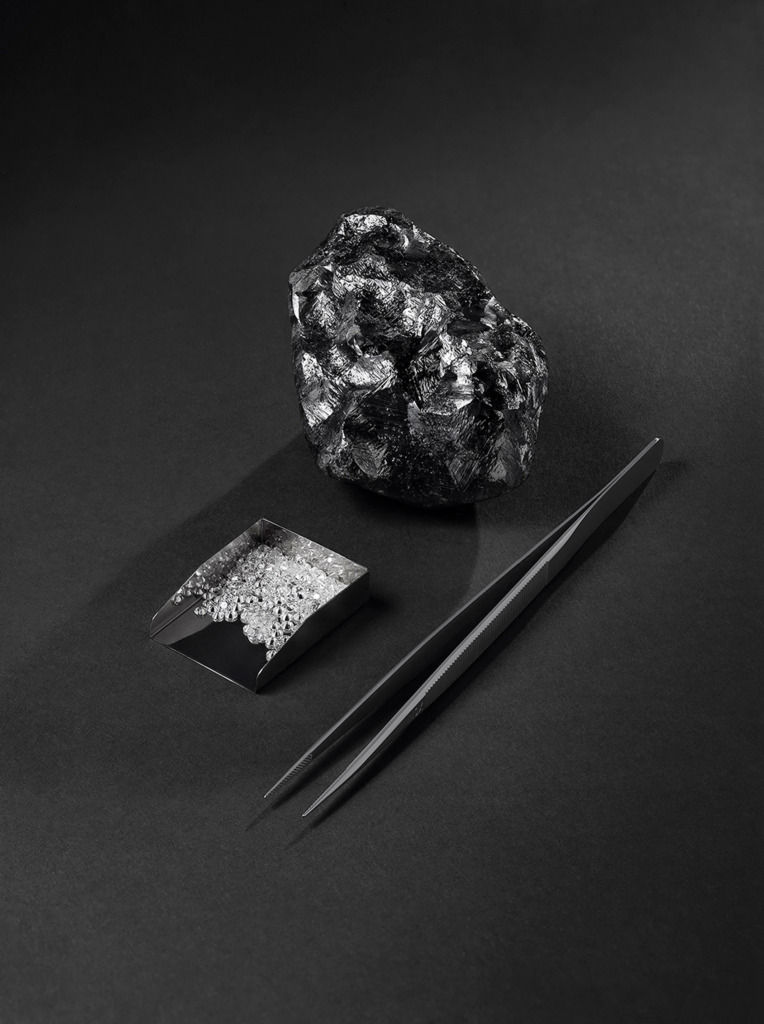 The Sewelô diamond alongside small white diamonds and a tweezer