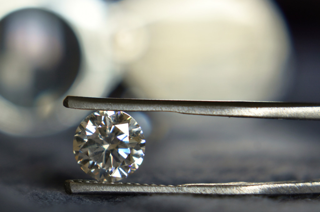 A natural diamond alongside the tools of grading